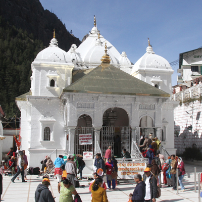 Gangotri Dham temple surrounded by snow peaks